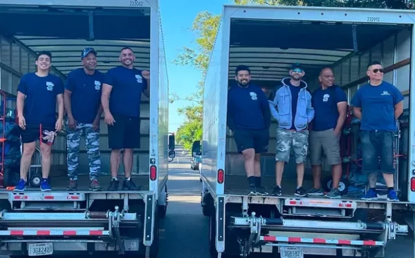 Movers smiling on trucks during moving day.