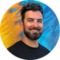 Man smiling with colorful background.